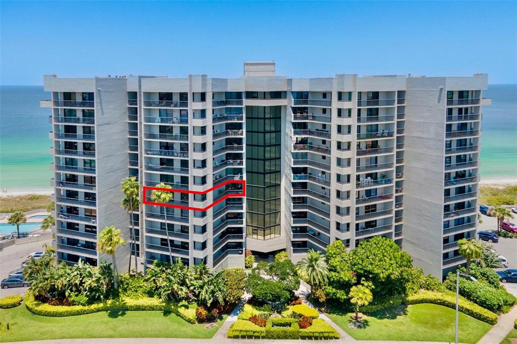 An exterior view of a multi-story beachfront condominium building with a red outline highlighting a balcony — 1660 GULF BOULEVARD UNIT 607, CLEARWATER BEACH, FL