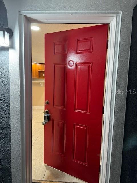 A bright red front door opens into a room with light-colored tile flooring — 2847 W HARWOOD STREET, ORLANDO, FL