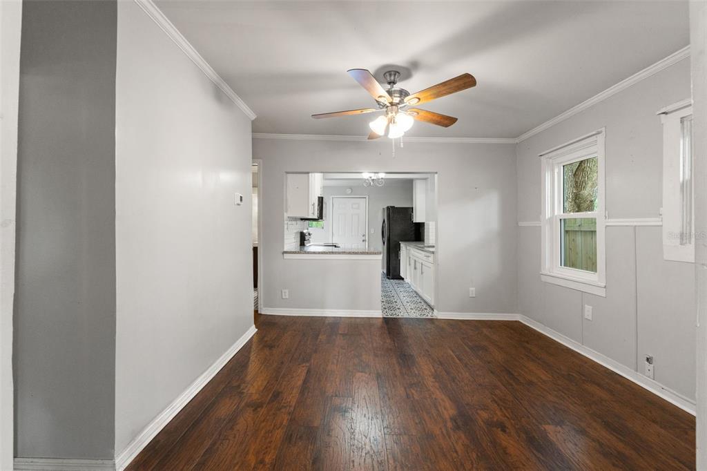 A dining room with dark wood flooring, light gray walls, and a ceiling fan — 5518 11TH STREET, ZEPHYRHILLS, FL