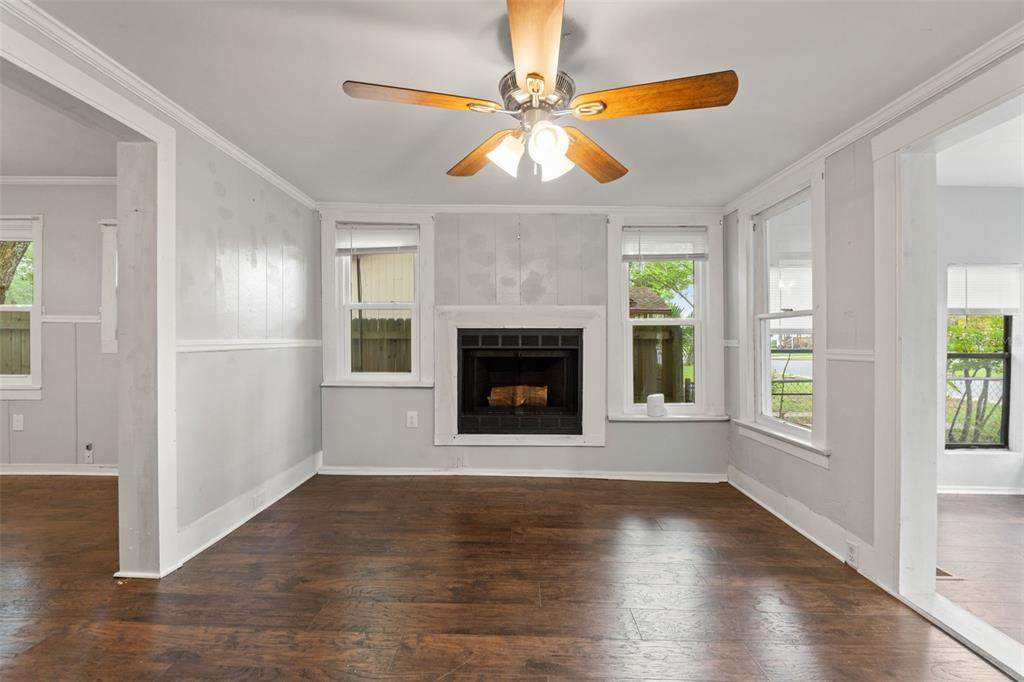 A living room features dark wood flooring, a central fireplace, and a ceiling fan — 5518 11TH STREET, ZEPHYRHILLS, FL