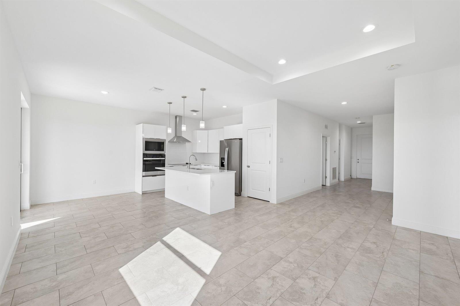 A modern kitchen with white cabinetry, stainless steel appliances, and a central island — 9006 S Castle Circle, FL 33935, FL