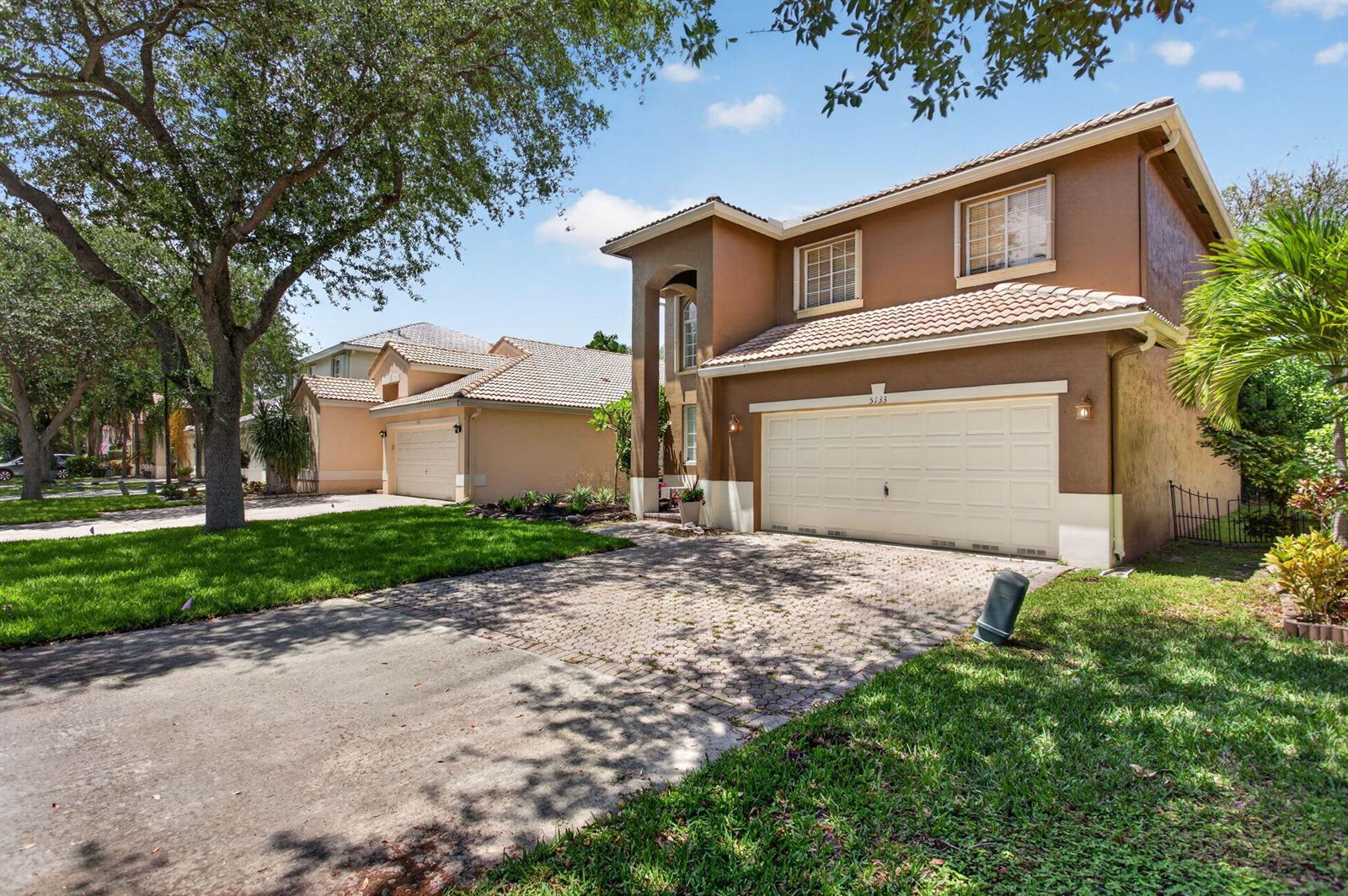 A two-story brown house with a tiled roof and a paved driveway sits on a lawn — 5133 Heron Place, Coconut Creek FL 33073, COCONUT CREEK, FL