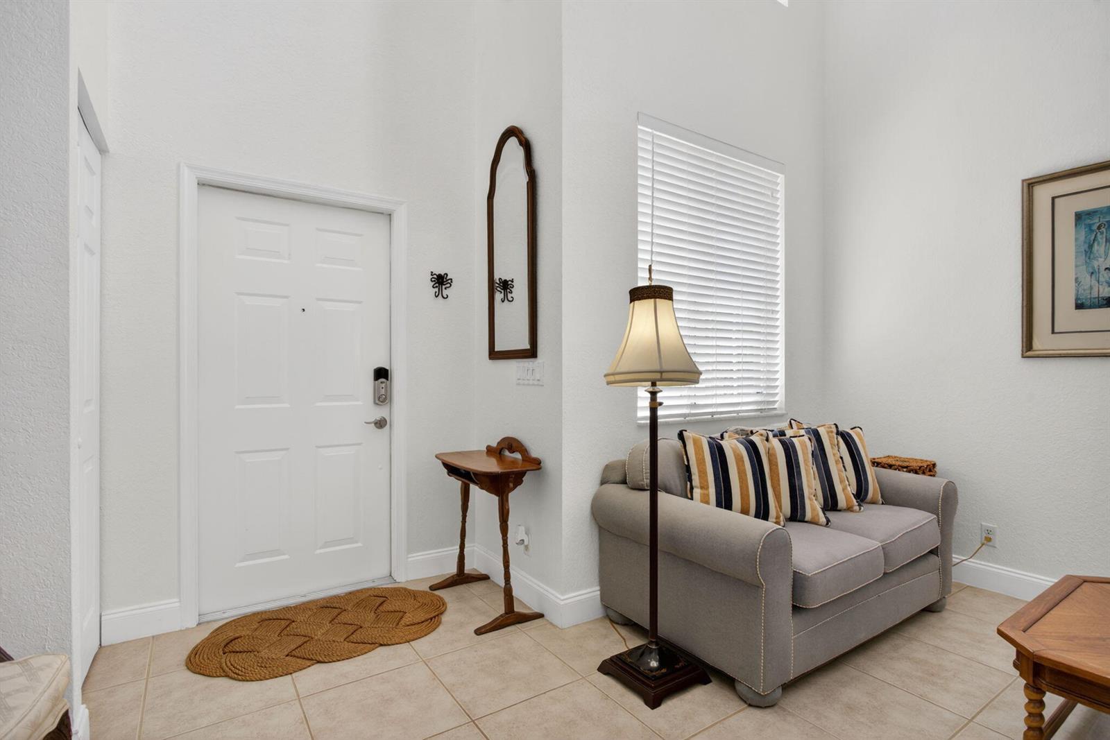 A living room features a grey sofa, a floor lamp, and a small wooden table — 5133 Heron Place, Coconut Creek FL 33073, COCONUT CREEK, FL