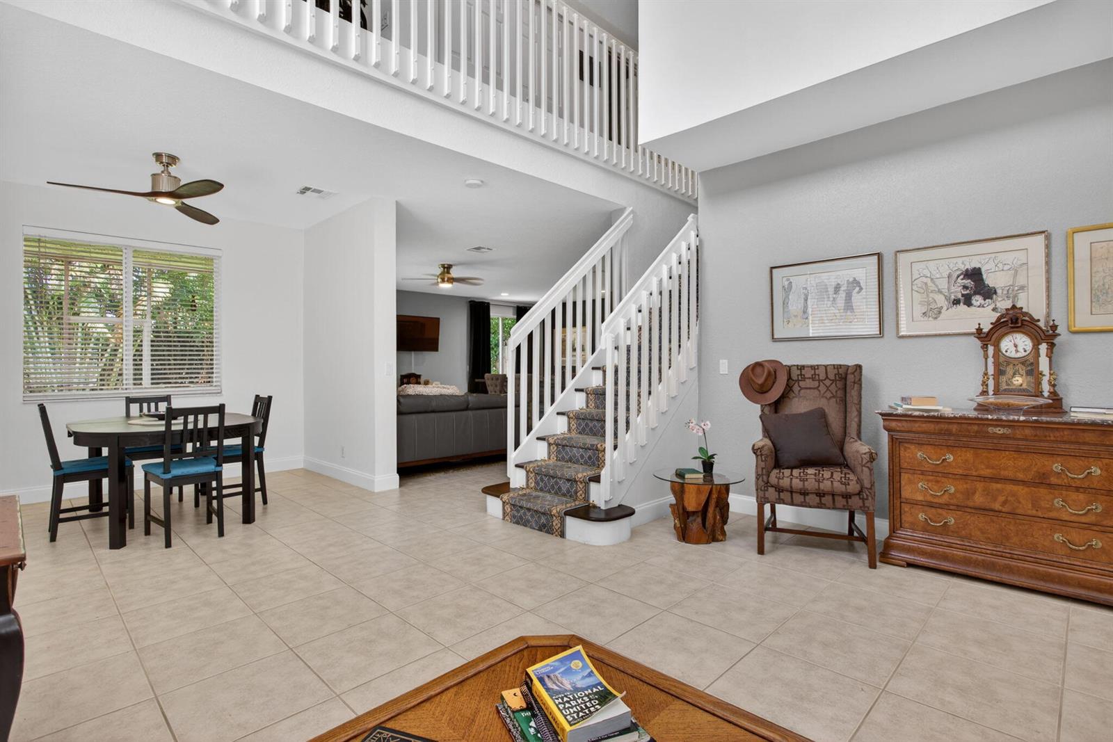 A living area features a dining set, a staircase with patterned carpet, and a wooden dresser — 5133 Heron Place, Coconut Creek FL 33073, COCONUT CREEK, FL