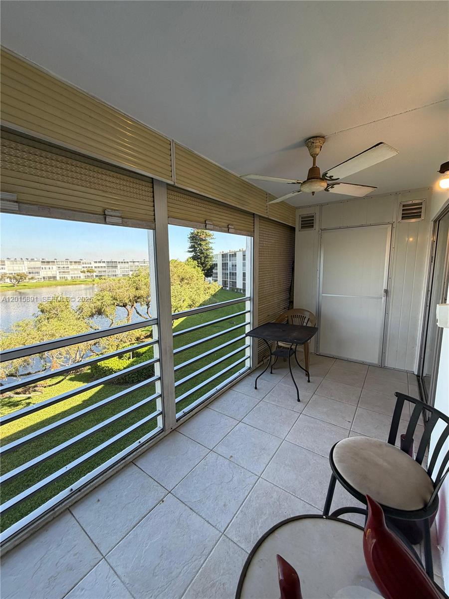 A tiled balcony features a ceiling fan, outdoor furniture, and views of a lake — 3032 Hythe B # 3032, Boca Raton FL 33434, BOCA RATON, FL