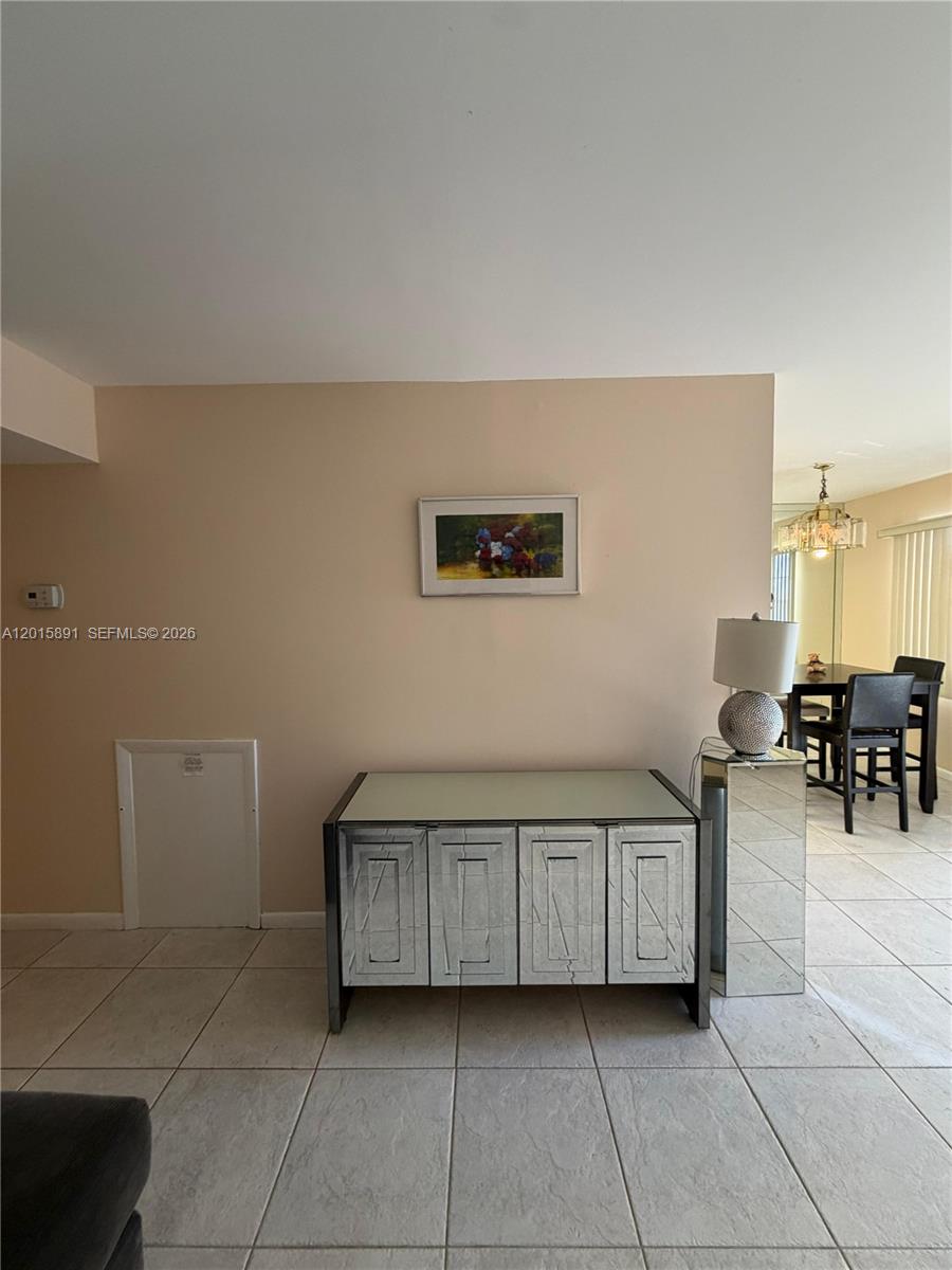 A mirrored sideboard sits against a beige wall beneath a framed painting in a room — 3032 Hythe B # 3032, Boca Raton FL 33434, BOCA RATON, FL