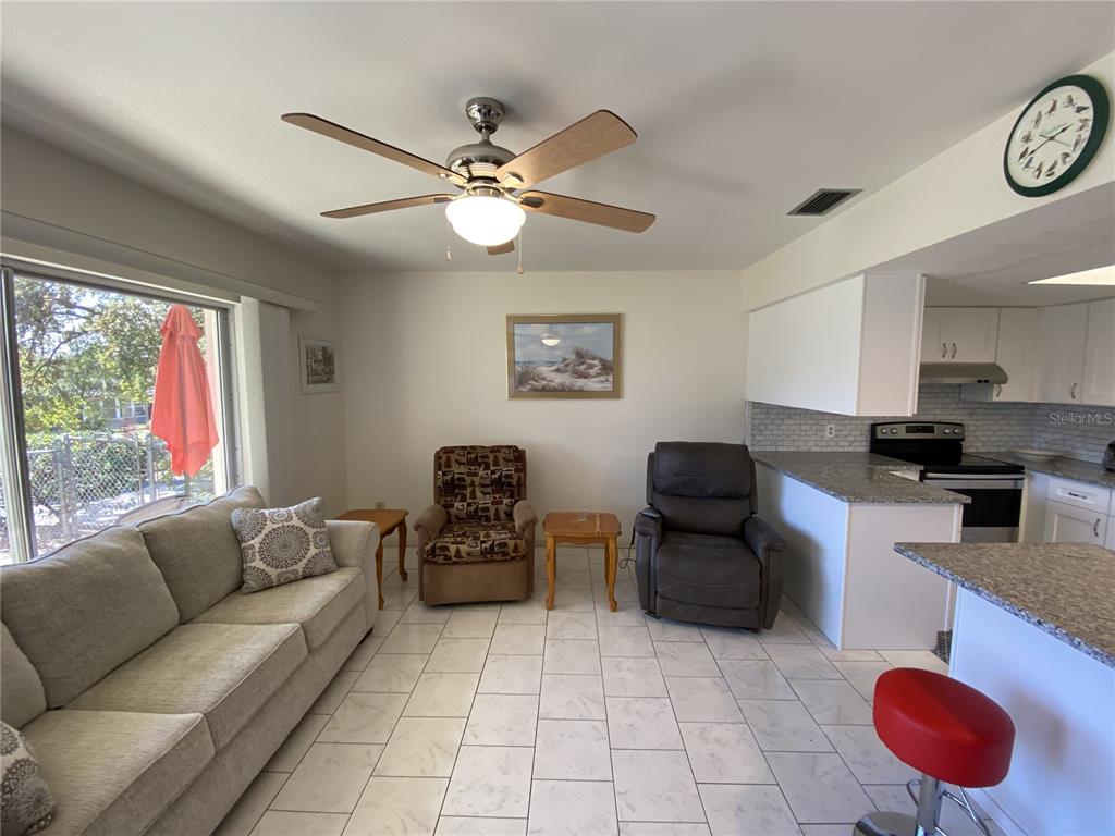 A living room with tile floors, a ceiling fan, a sofa, and two armchairs — 711 SPRINGER DRIVE UNIT 9, LAKE WALES, FL