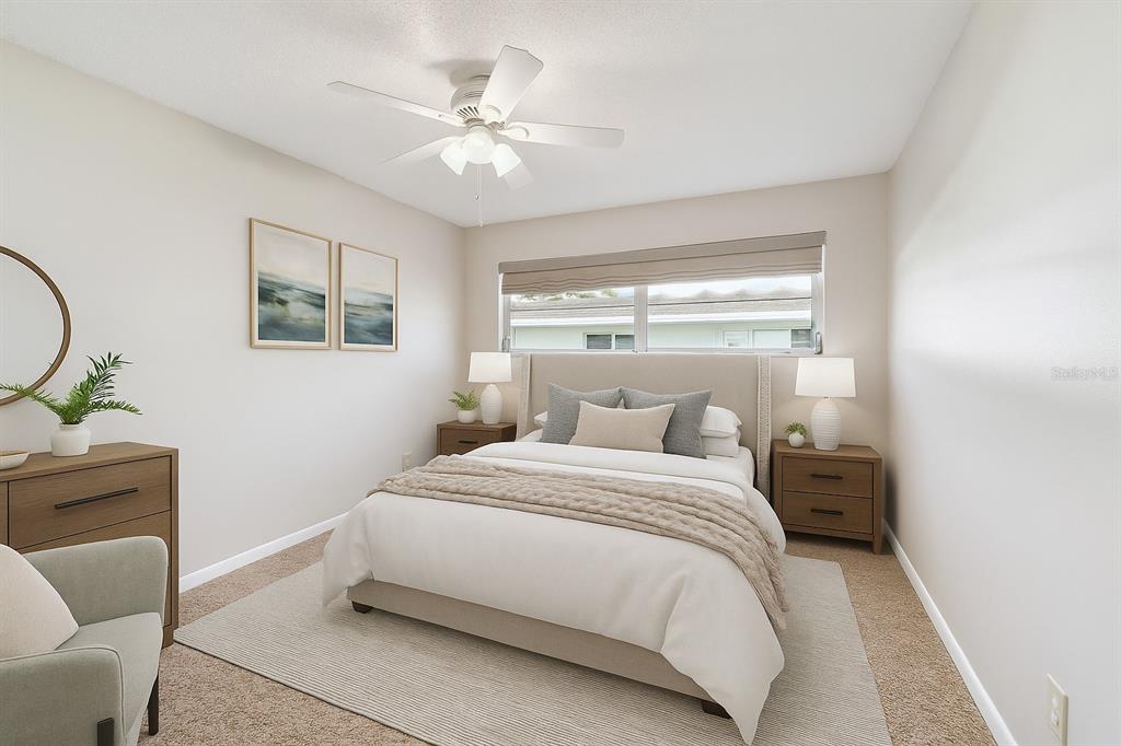 A bedroom features a bed with a neutral headboard, two nightstands, and a ceiling fan — 11200 102ND AVENUE UNIT 33, SEMINOLE, FL