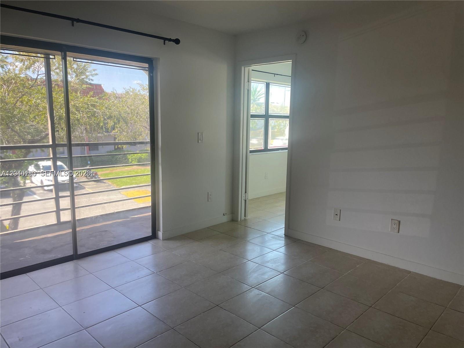 A shower with white tiled walls, a black showerhead, and a wooden floor mat — 20825 NE 8th Ct # 19, Miami FL 33179, MIAMI, FL