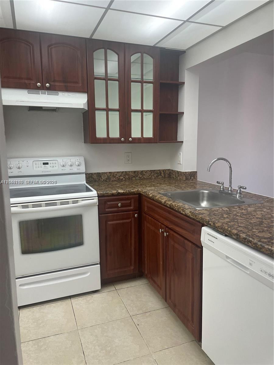 A stacked washer and dryer unit is located in a small closet in a hallway — 20825 NE 8th Ct # 19, Miami FL 33179, MIAMI, FL