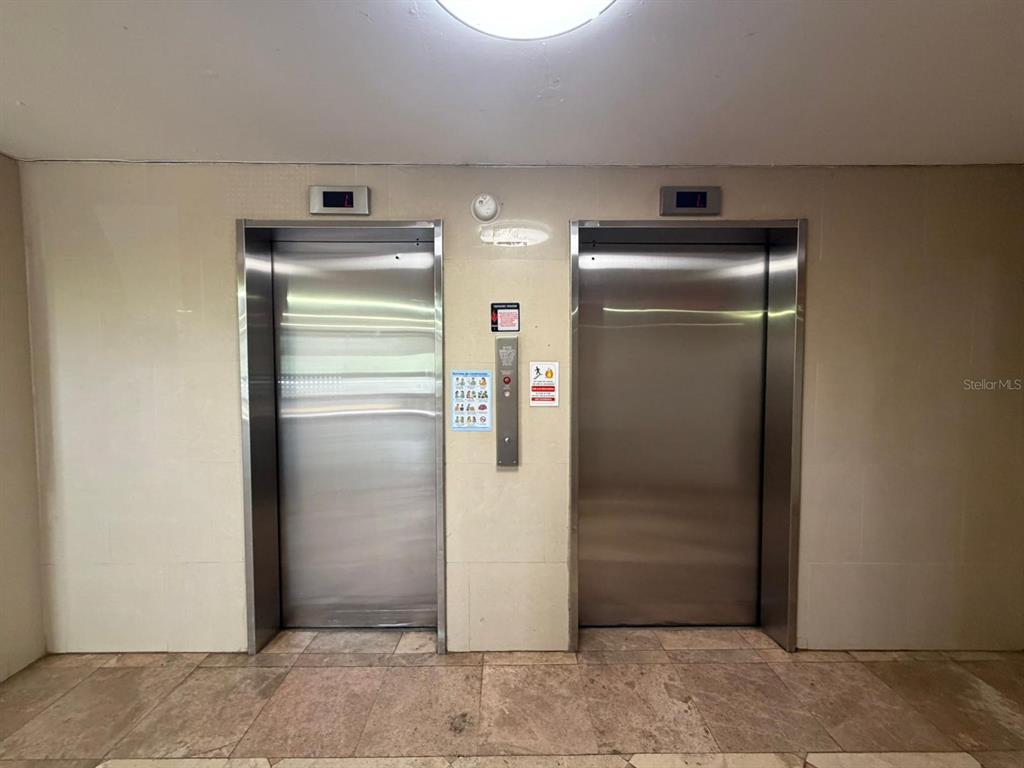 Two stainless steel elevator doors are set into a beige tiled wall — 1 CLL ALMONTE UNIT 1707, SAN JUAN, PR