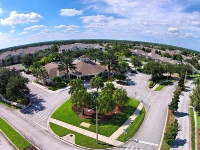 An aerial view of a community clubhouse surrounded by palm trees, parking, and residential buildings — 2307 BUTTERFLY PALM WAY UNIT # 102, KISSIMMEE, FL