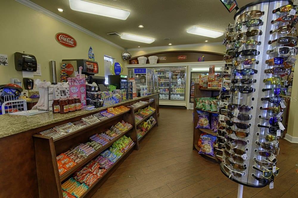 A convenience store interior features a snack display counter, refrigerated cases, and a sunglasses rack — 2307 BUTTERFLY PALM WAY UNIT # 102, KISSIMMEE, FL