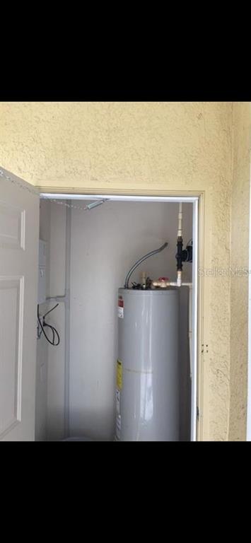 A water heater is installed inside a small utility closet with a white door — 18001 RICHMOND PLACE DRIVE UNIT 220, TAMPA, FL