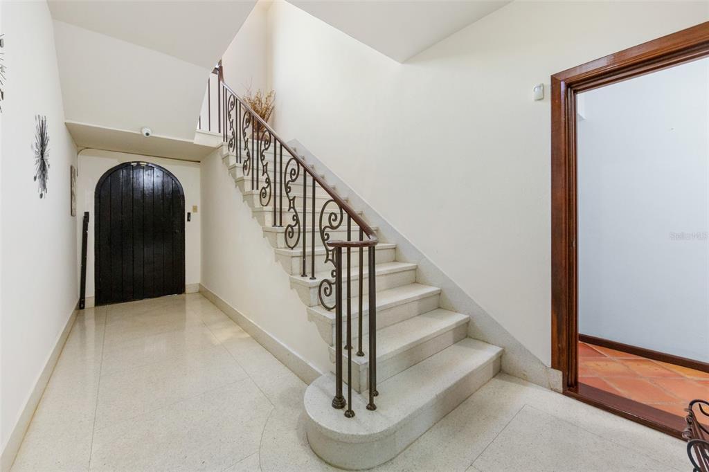 A staircase with white stone steps and a decorative metal railing in a foyer — 550 WAYMOUTH, MIRAMAR, SAN JUAN, PR