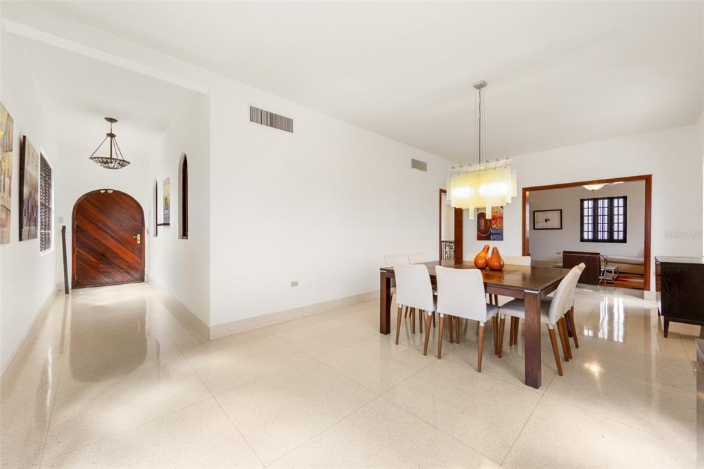 A dining room with a wooden table, white chairs, and a modern chandelier on tile floors — 550 WAYMOUTH, MIRAMAR, SAN JUAN, PR