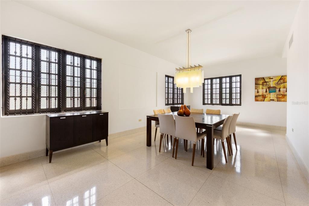 A dining room with a dark wood table, six chairs, and large windows with grilles — 550 WAYMOUTH, MIRAMAR, SAN JUAN, PR