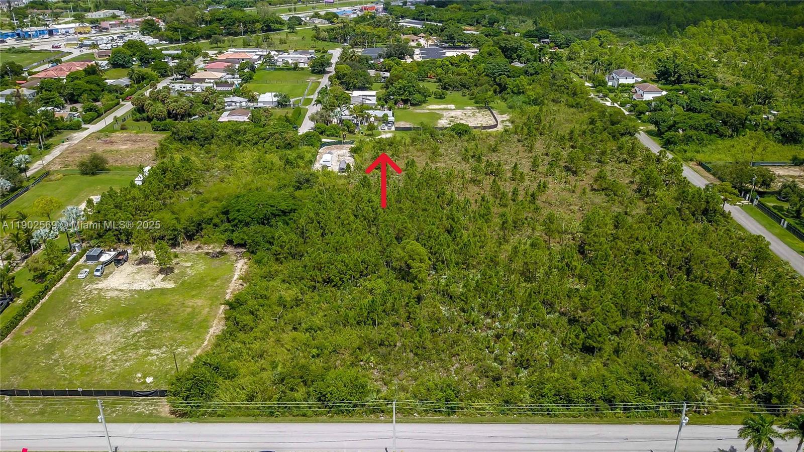 An aerial view shows a large, wooded vacant lot with a red arrow pointing toward it — 12251 SW 230th Street, Miami FL 33170, MIAMI, FL