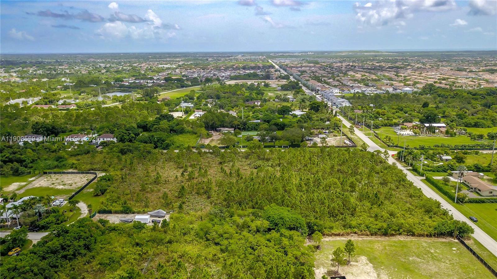 An aerial view shows a large, undeveloped wooded lot adjacent to a suburban residential neighborhood — 12251 SW 230th Street, Miami FL 33170, MIAMI, FL