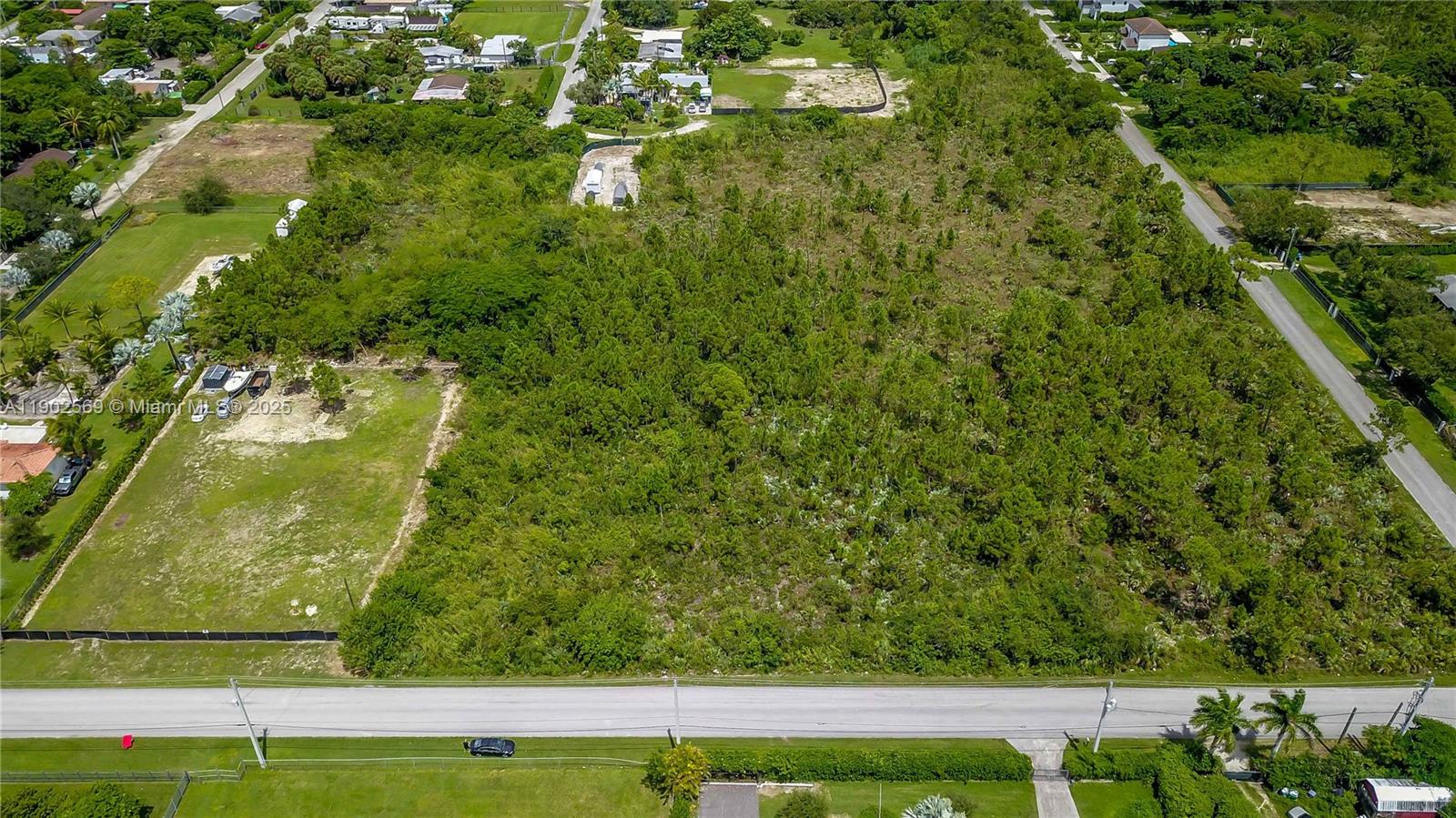 An aerial view shows a large, undeveloped wooded lot bordered by a road and residential properties — 12251 SW 230th Street, Miami FL 33170, MIAMI, FL