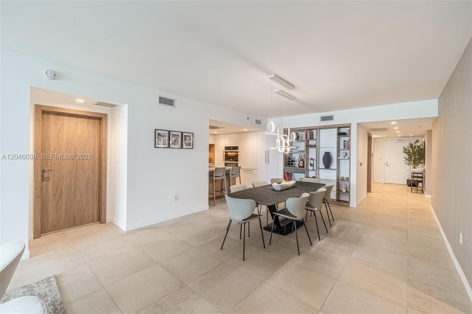 A dining area features a dark table, modern chairs, and a built-in shelving unit — 1135 103rd St # 405, Bay Harbor Islands FL 33154, BAY HARBOR ISLANDS, FL