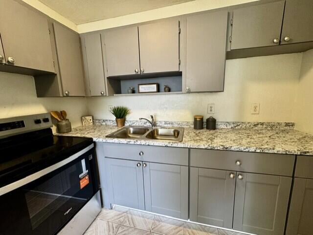 A kitchen features gray cabinets, granite countertops, and a stainless steel stove — 116 N F Street # 7, FL 33460, FL