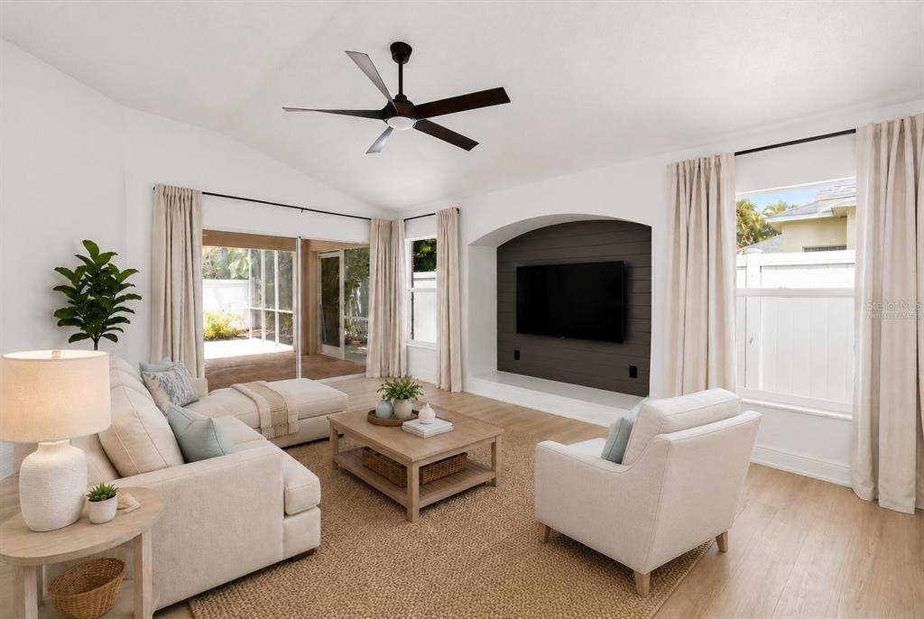 A living room features a sectional sofa, armchair, coffee table, and a wall-mounted television — 6226 BLUEFLOWER COURT, LAKEWOOD RANCH, FL