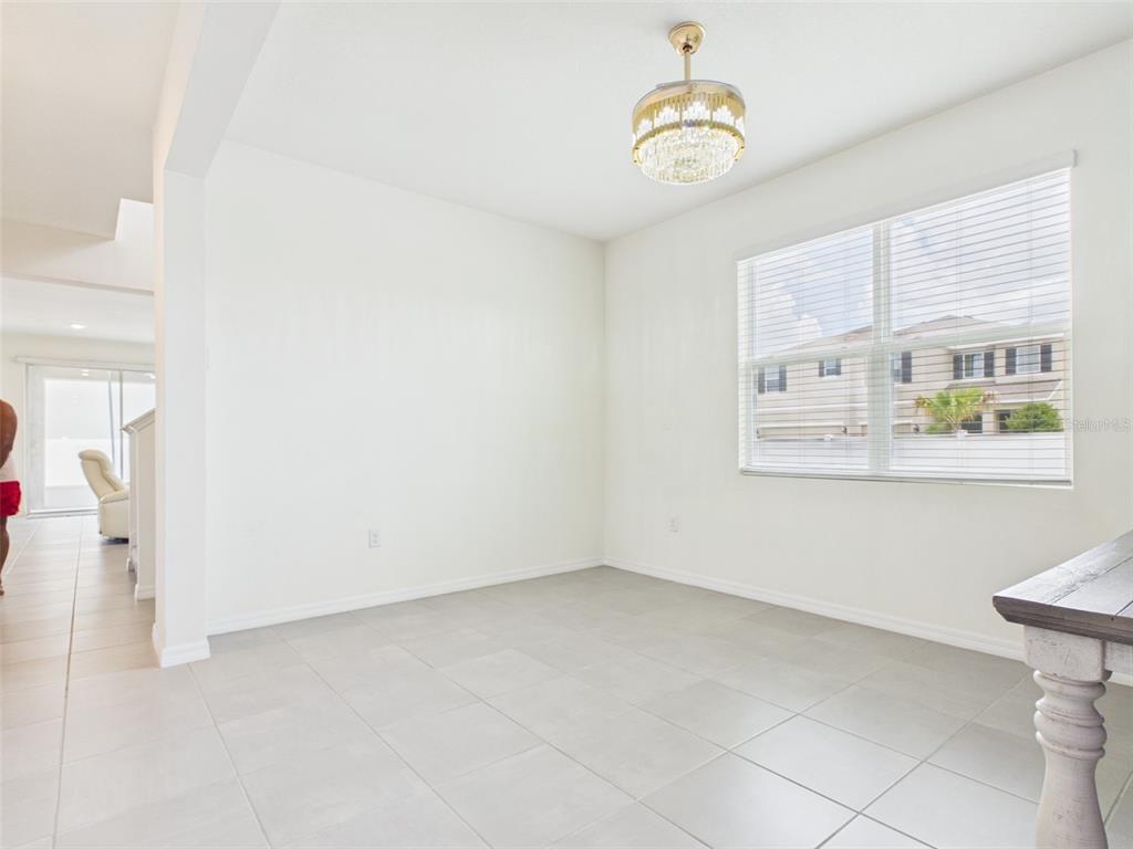 A dining room with light tile flooring, white walls, and a crystal chandelier — 5962 SW 80TH LN, OCALA, FL