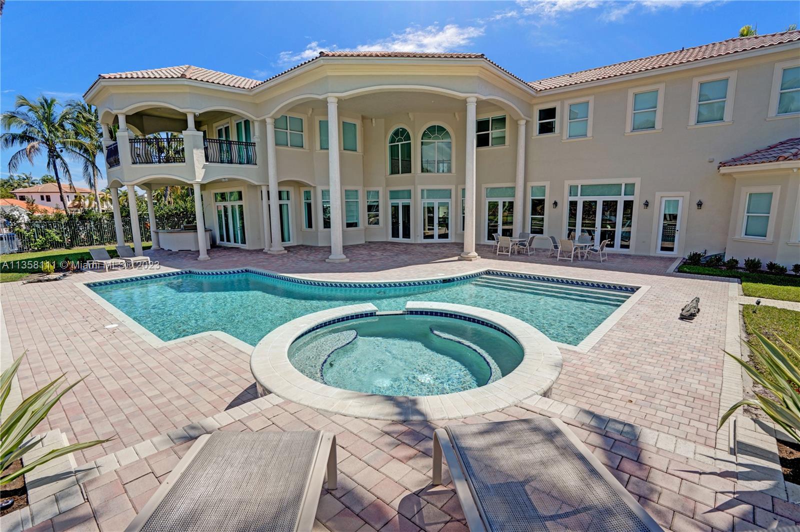 A large two-story house features a swimming pool, a circular hot tub, and a patio — 1130 Harbor Ct, Hollywood FL 33019, HOLLYWOOD, FL