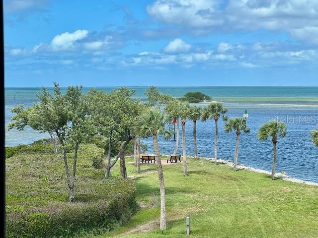 A grassy waterfront area features palm trees, benches, and a view of the ocean — 3280 SOUTHSHORE DRIVE UNIT 85C, PUNTA GORDA, FL