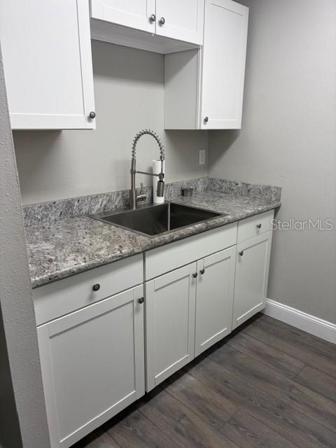 A kitchen area features white cabinets, granite countertops, and a stainless steel sink with faucet — 24862 N US HIGHWAY 19 UNIT 803, CLEARWATER, FL