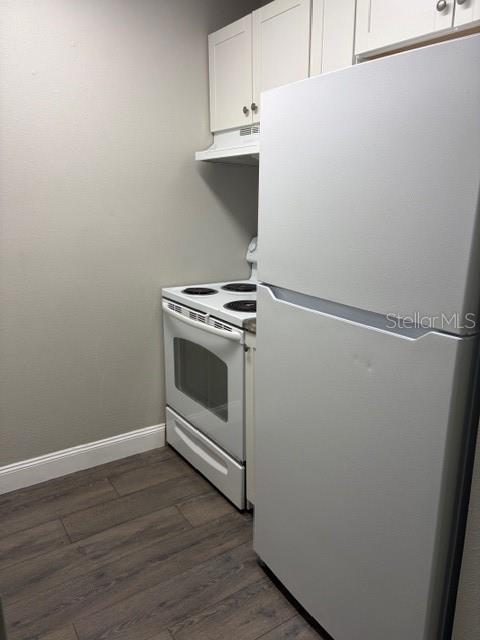 A kitchen features a white refrigerator, a white electric range, and white upper cabinets — 24862 N US HIGHWAY 19 UNIT 803, CLEARWATER, FL