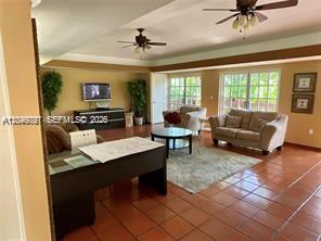 A living room with tile floors, two ceiling fans, a desk, and a sofa — 9938 Nob Hill Pl # 1838, Sunrise FL 33351, SUNRISE, FL