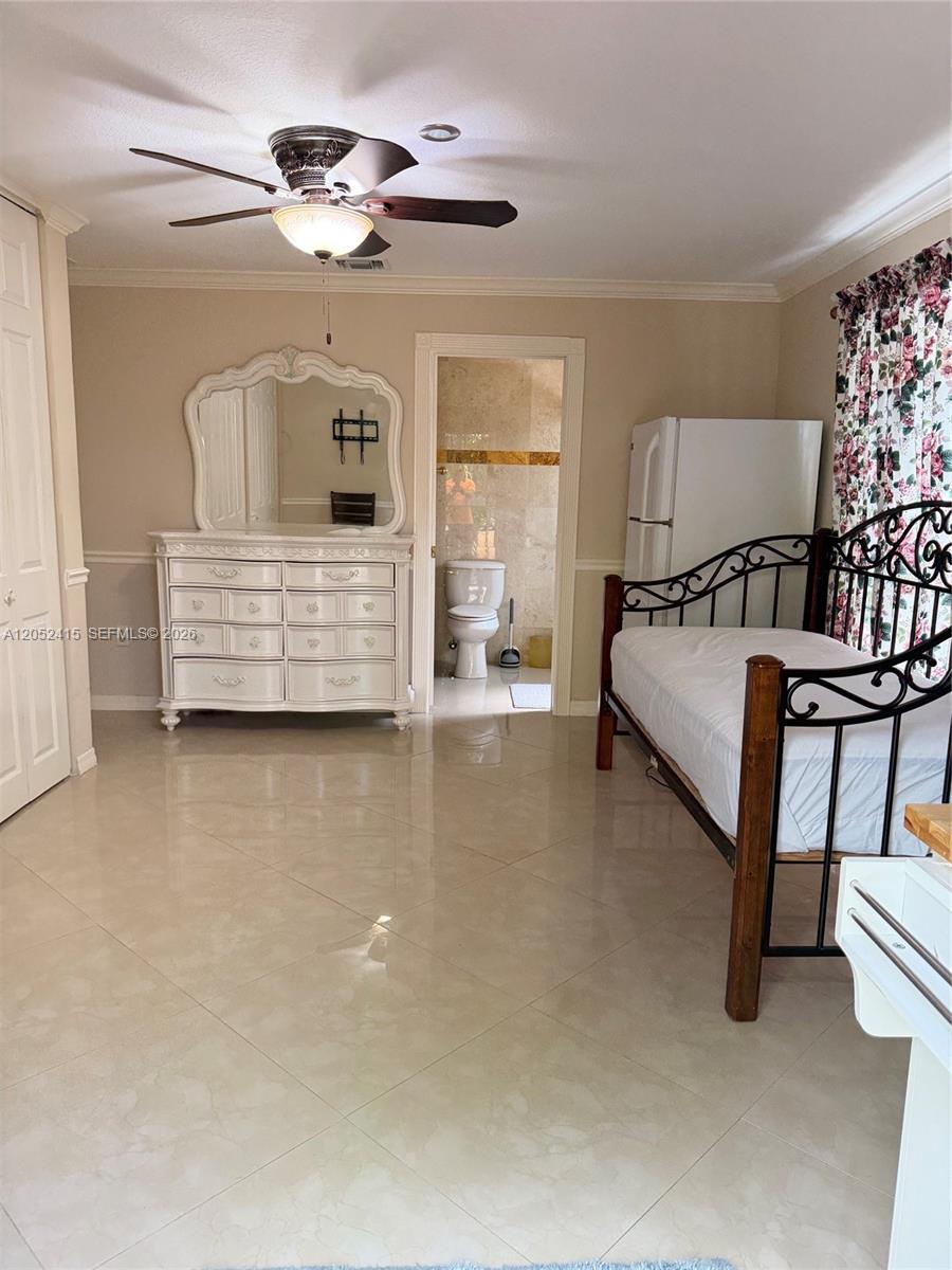 A bedroom features a white dresser, a metal bed frame, and an attached bathroom — 21920 Old Cutler Rd # 0, Cutler Bay FL 33190, CUTLER BAY, FL