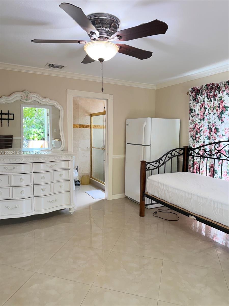 A bedroom features a white dresser, a metal bed frame, and an attached bathroom — 21920 Old Cutler Rd # 0, Cutler Bay FL 33190, CUTLER BAY, FL