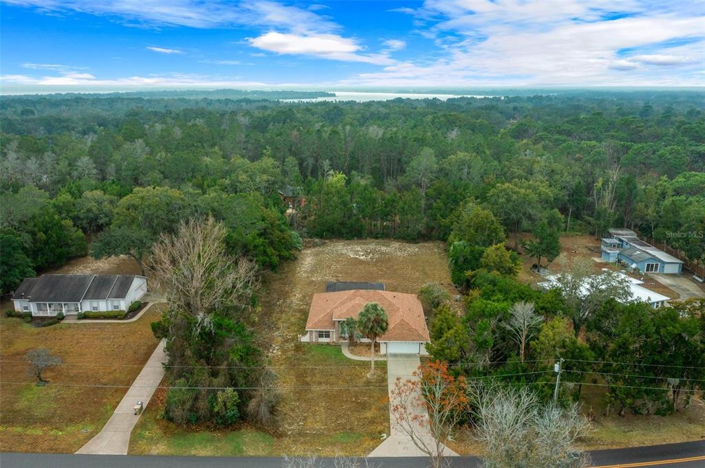 An aerial view shows a single-story house with a brown roof and a large backyard — 36014 LAKE UNITY NURSERY ROAD, FRUITLAND PARK, FL