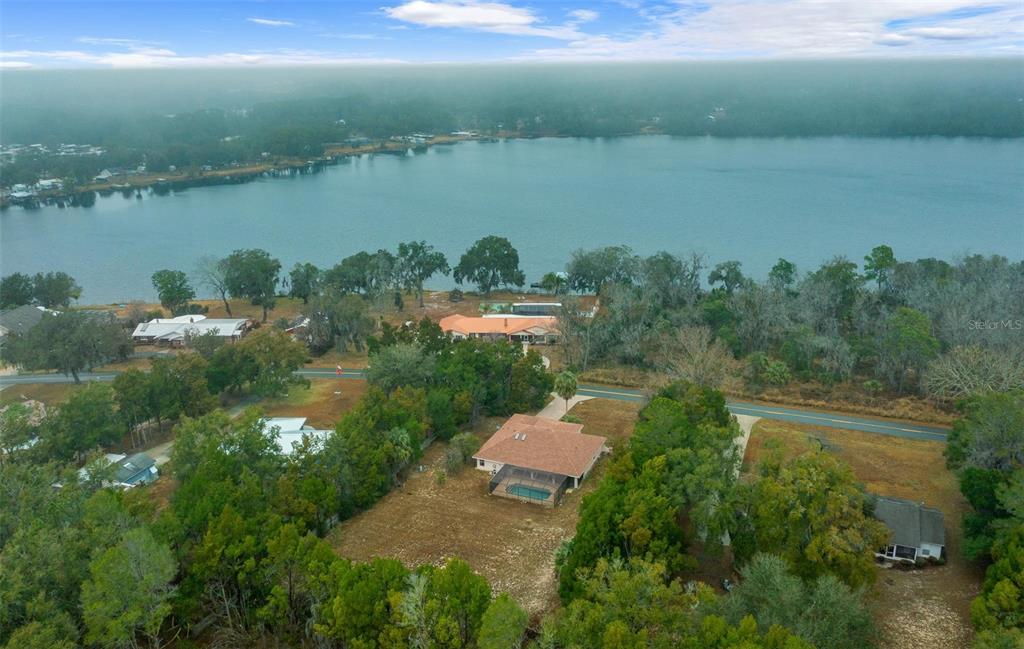 An aerial view shows a house with a pool near a lake and trees — 36014 LAKE UNITY NURSERY ROAD, FRUITLAND PARK, FL