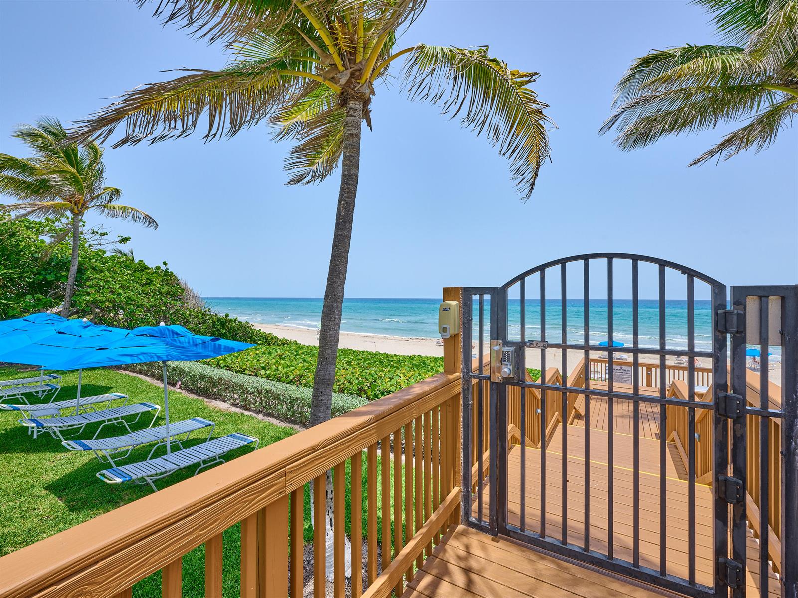 A wooden deck with lounge chairs and a gate overlooks a beach and the ocean — 3420 S Ocean Boulevard, Highland Beach FL 33487, HIGHLAND BEACH, FL