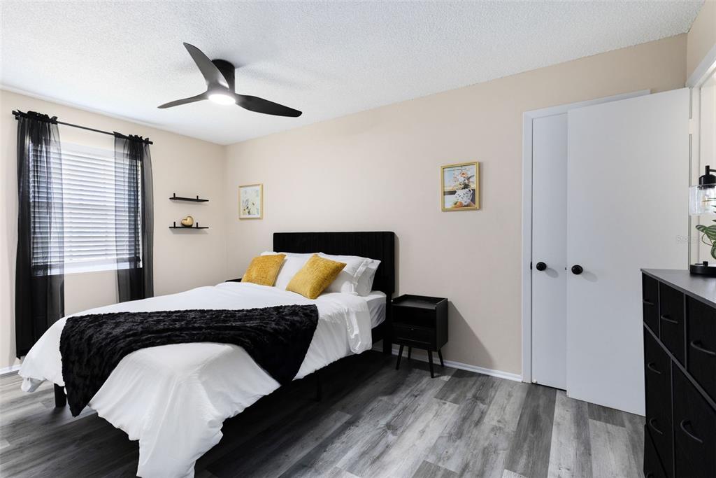 A kitchen with white cabinets and a breakfast bar opens into a dining and living area — 1228 E MURIEL STREET, ORLANDO, FL