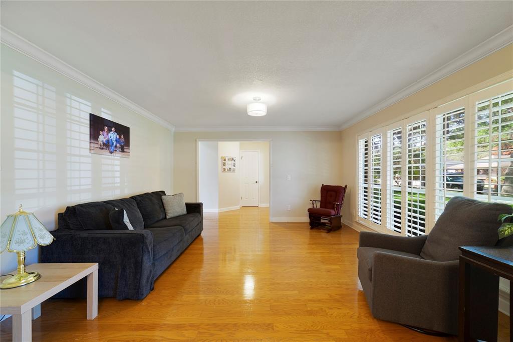 A living room with hardwood floors, a grey sofa, and an adjacent dining area — 749 WILLOW RUN LANE, WINTER SPRINGS, FL
