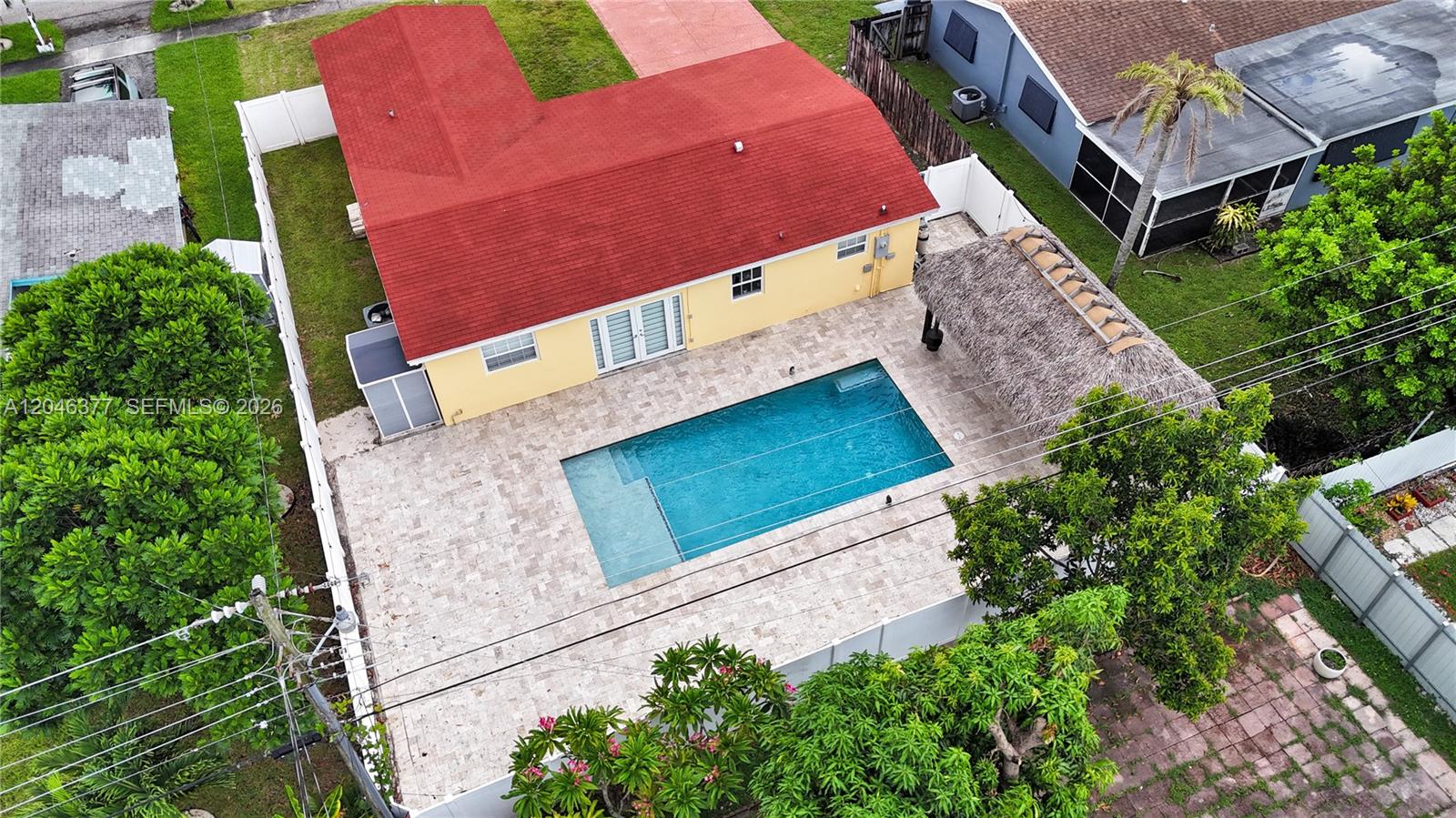 An aerial view shows a yellow house with a red roof, pool, and tiki hut — 6431 S Coolidge St, Hollywood FL 33024, HOLLYWOOD, FL