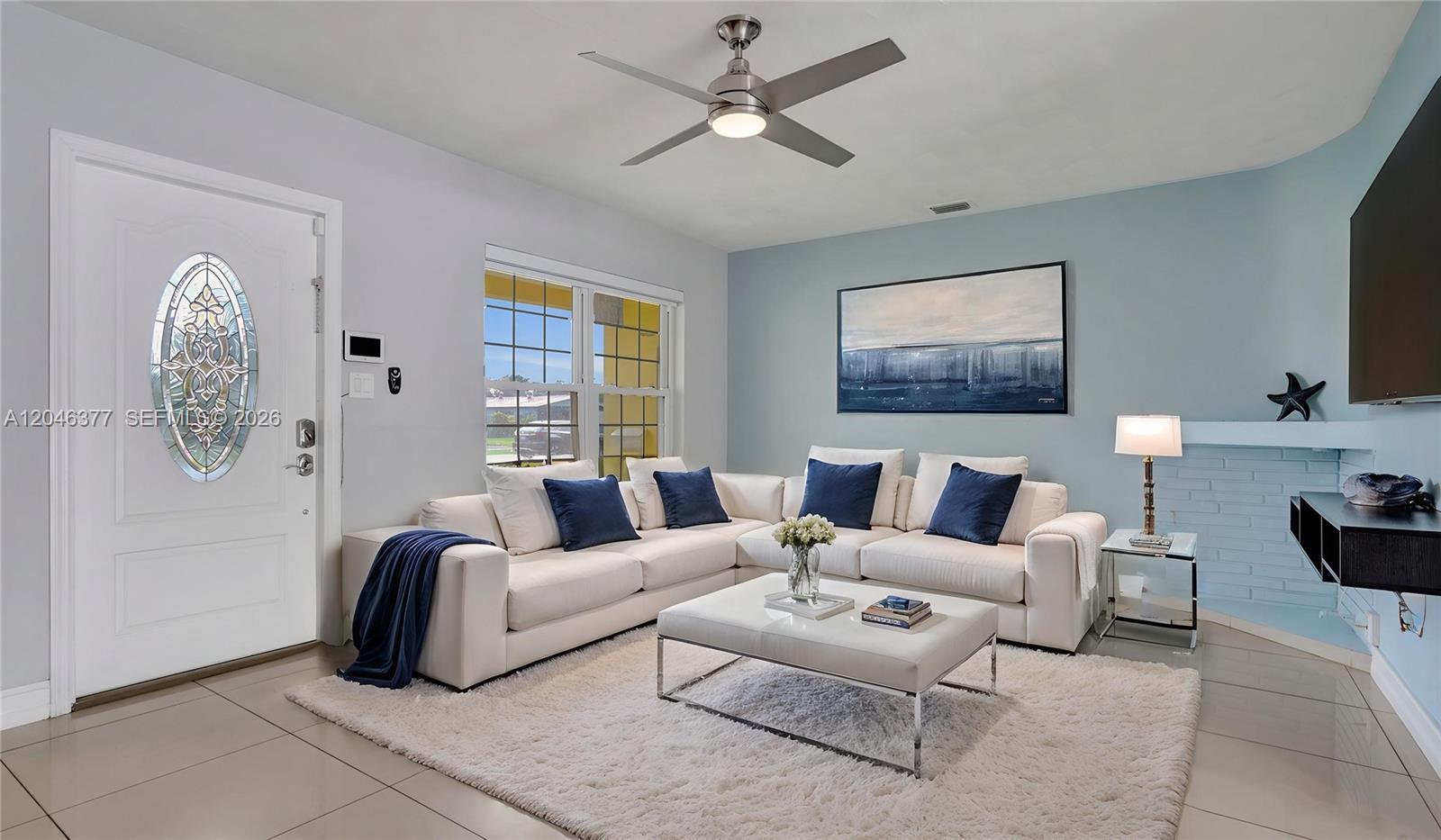 A living room features a white sectional sofa, a coffee table, and a ceiling fan — 6431 S Coolidge St, Hollywood FL 33024, HOLLYWOOD, FL