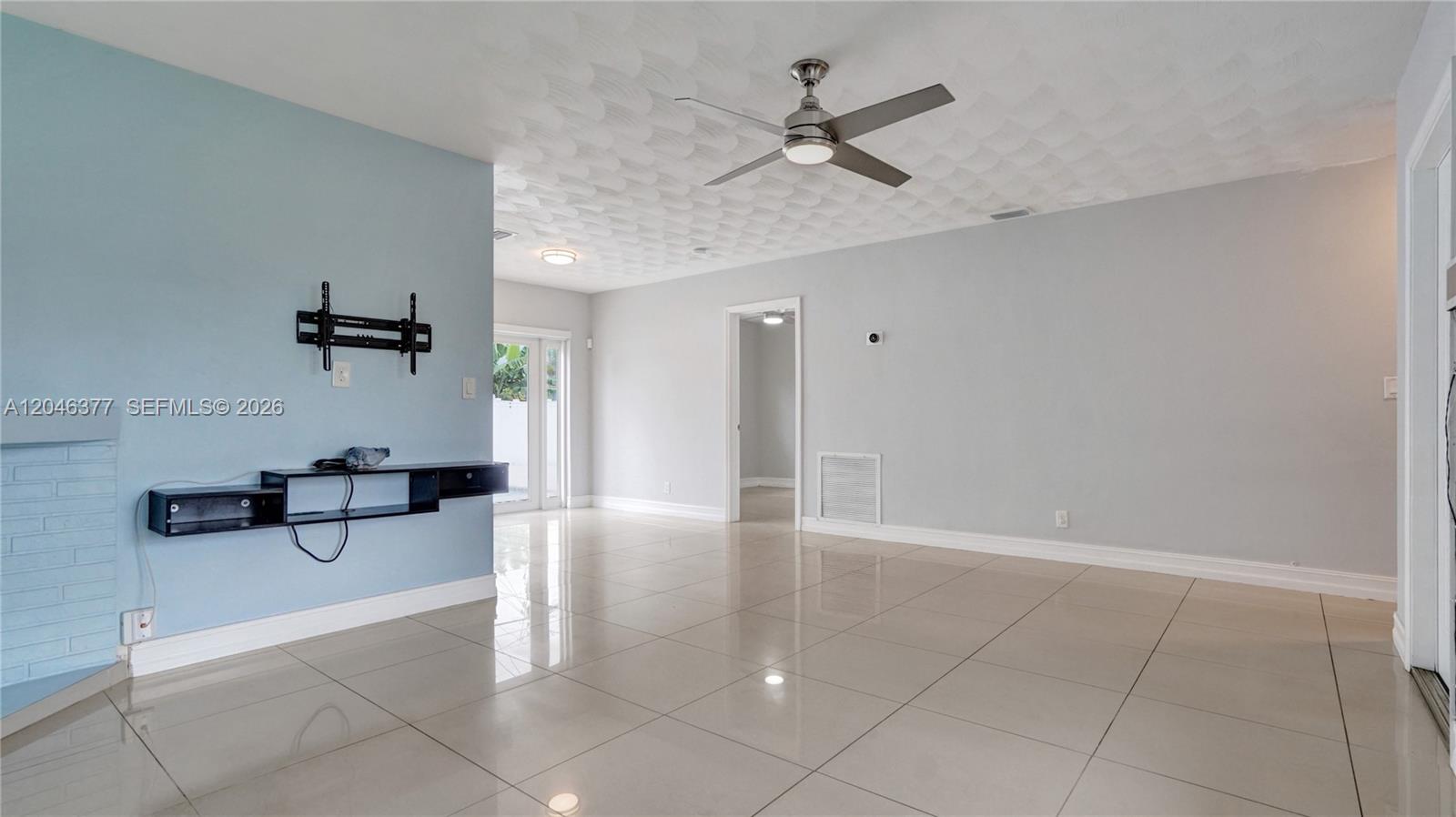 A living room features light blue and gray walls, tile flooring, and a ceiling fan — 6431 S Coolidge St, Hollywood FL 33024, HOLLYWOOD, FL