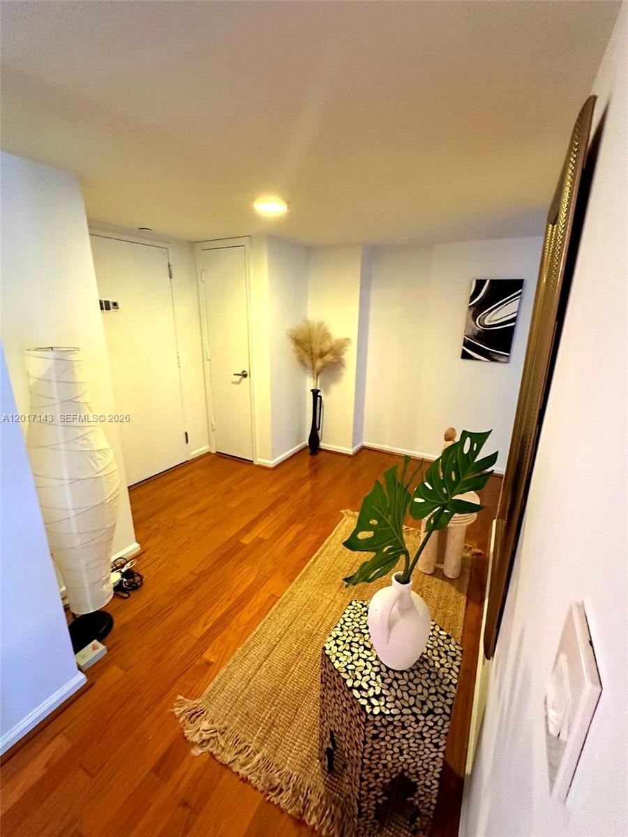 An entryway features hardwood floors, a textured side table, a floor lamp, and wall art — 1370 S Ocean Blvd # 902, Pompano Beach FL 33062, POMPANO BEACH, FL
