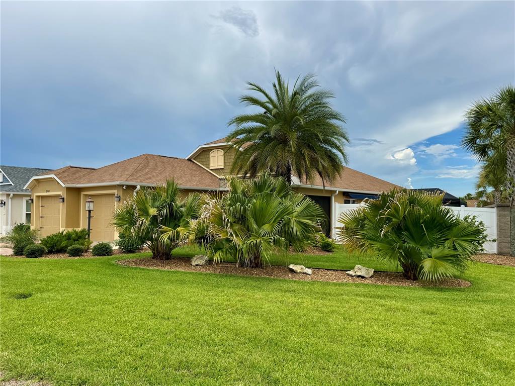 A single-story house with a tan exterior, a brown roof, and palm trees in the yard — 3568 FARRELL AVENUE, THE VILLAGES, FL