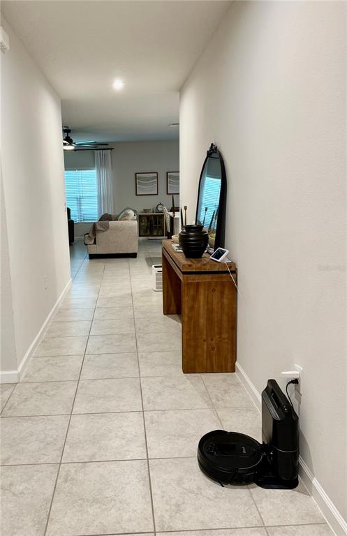 A tiled hallway leads to a living area featuring a wooden console table and mirror — 1562 LANDON LANE, HAINES CITY, FL
