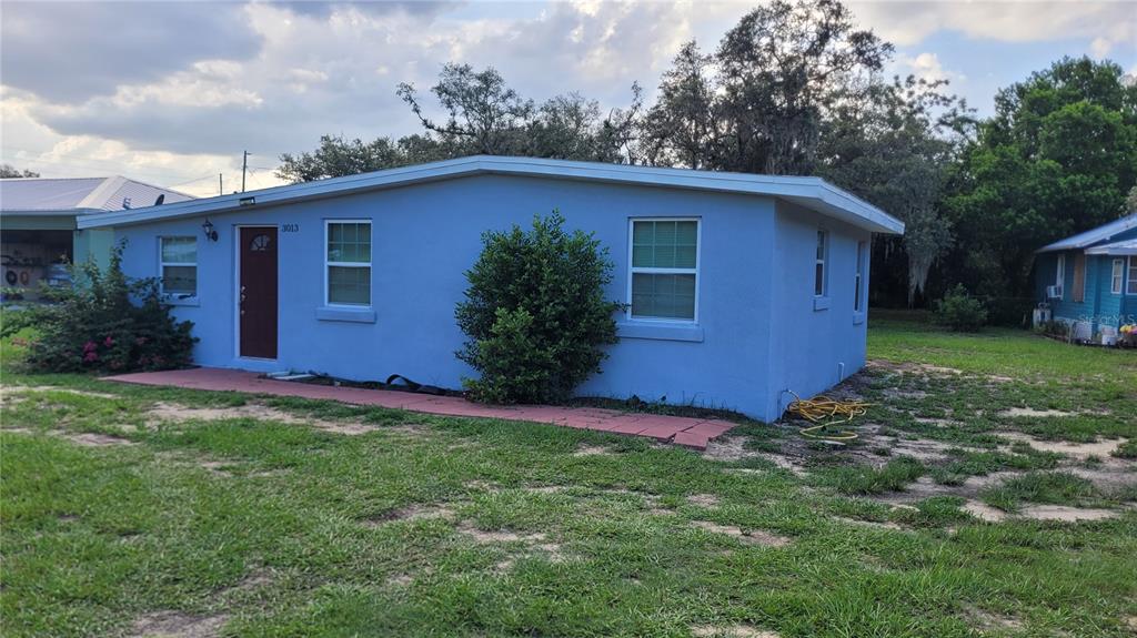 A single-story blue house with a red door and a red brick walkway — 3013 LAUREL AVENUE, LAKE WALES, FL