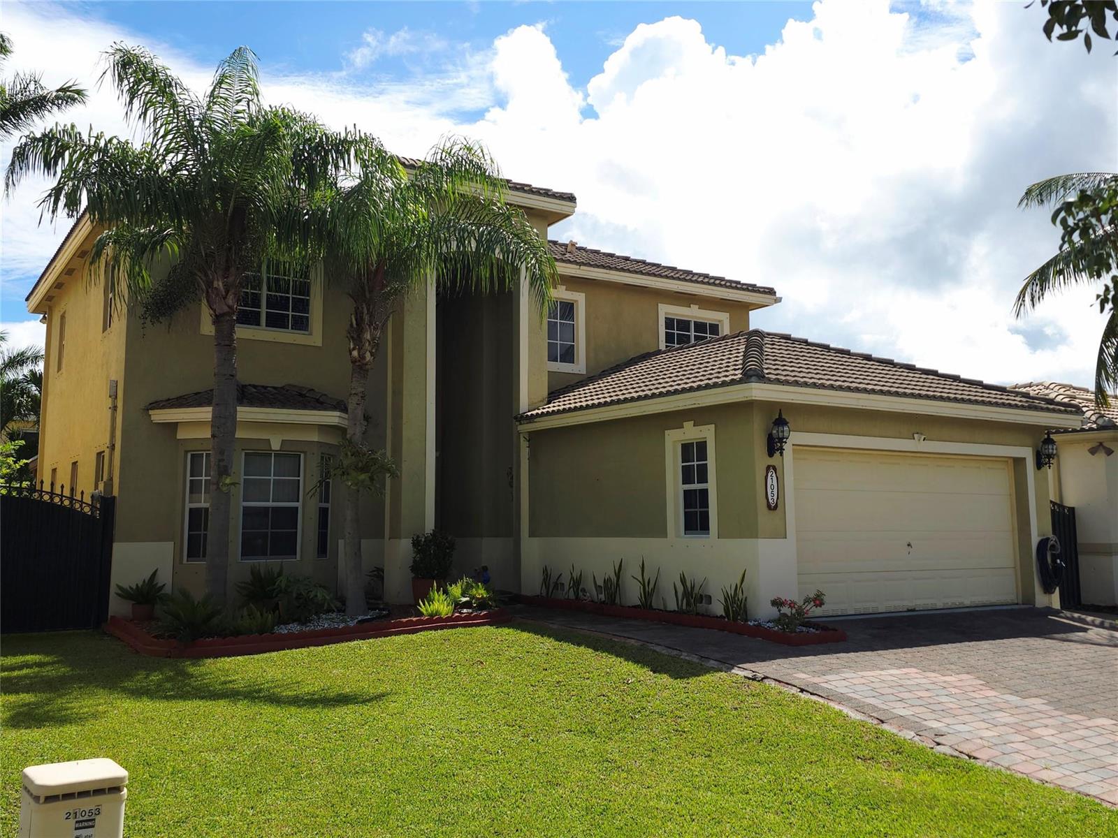 A two-story house with a tan exterior, a tiled roof, and a paved driveway — 21053 SW 88th Place, Cutler Bay FL 33189, CUTLER BAY, FL