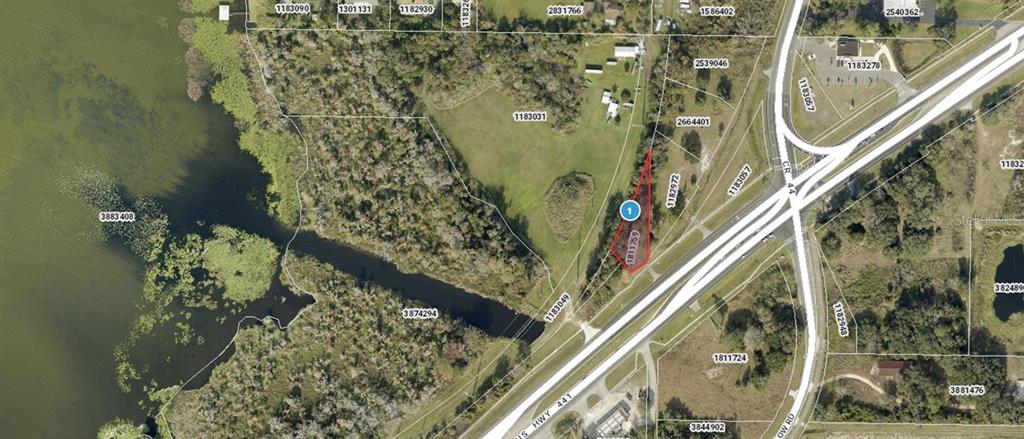 This is an aerial map showing a highlighted parcel of land near a highway intersection — 7503 US HIGHWAY 441, LEESBURG, FL