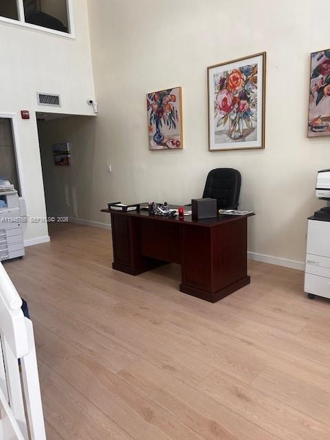 An office space features a dark wood desk, a black chair, and floral wall art — 13318 SW 128th St, Miami FL 33186, MIAMI, FL